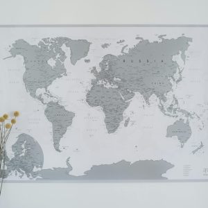 A minimalist wall decor featuring a gray world map with dried craspedia flowers.